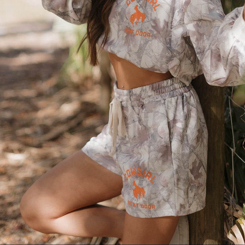 Person wearing a matching crop top and shorts set with 'Cowgirl Outdoors' branding.